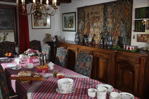 a dining room with a table with a red checked table cloth at Maison d'hôtes La Cerisaie in Breitenbach