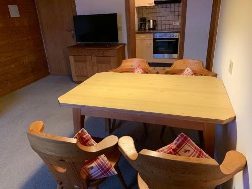a kitchen with a wooden table and chairs at Ferienwohnungen Max Schermer in Brixen im Thale