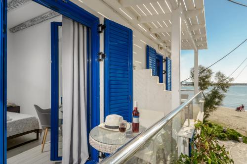 a balcony with blue doors and a table on the beach at Saint George Hotel in Naxos Chora