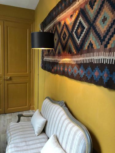 a living room with a couch and a rug at Hotel Du Cygne Tours in Tours