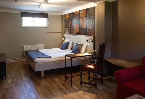 a bedroom with a bed and a table and a chair at Södra Hotellet in Norrköping