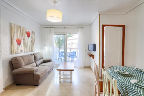 a living room with a couch and a table at Apartamentos BCL Playa Albir in Albir