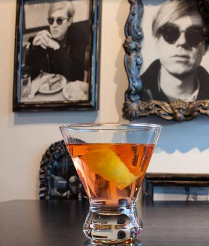 a drink with a lemon in a glass on a table at Lorenzo Hotel Dallas, Tapestry Collection by Hilton in Dallas