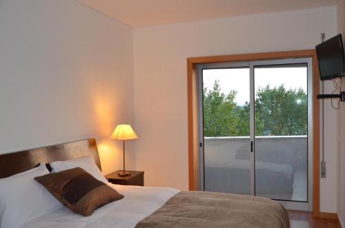 a bedroom with a bed and a sliding glass door at Next University in Aveiro