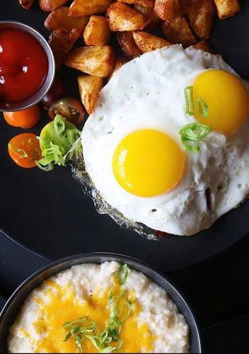 a plate of food with an egg and potatoes at Lorenzo Hotel Dallas, Tapestry Collection by Hilton in Dallas