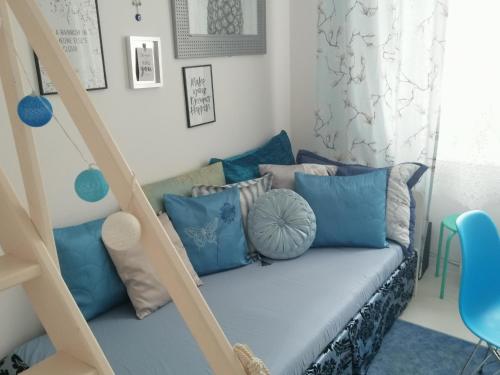 ウッチにあるDobraNocの青い枕とソファが備わる客室です。