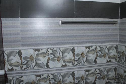 a shower curtain with a flower pattern on a wall at SR RESIDENCY in Vellore