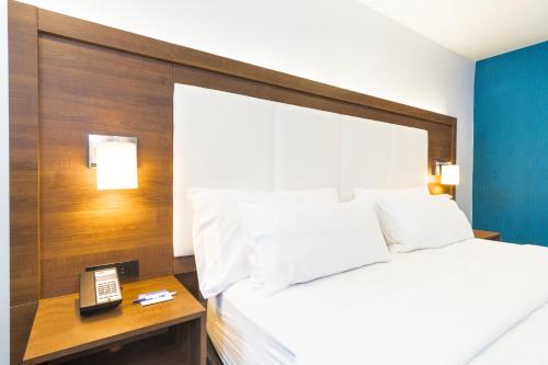 a bedroom with a bed and a phone on a table at Holiday Inn Express Hollywood Walk of Fame by IHG in Los Angeles