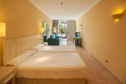 two beds in a room with a living room at IFA Altamarena by Lopesan Hotels in Morro del Jable