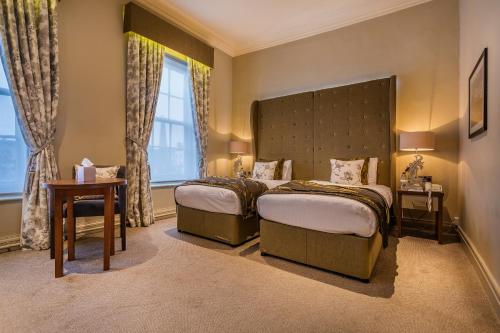 a hotel room with two beds and a large window at The Kings Head Hotel, Richmond, North Yorkshire - The Coaching Inn Group in Richmond
