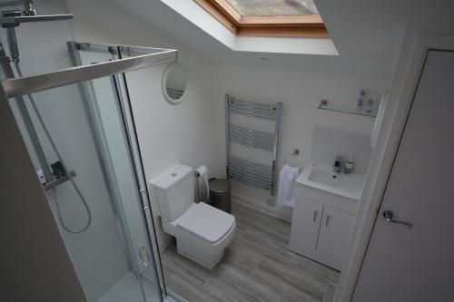 a white bathroom with a toilet and a sink at Pier Cottage in Watchet