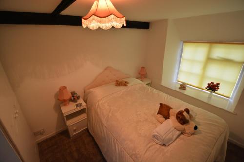 a bedroom with a bed with a teddy bear on it at Pier Cottage in Watchet