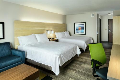 a hotel room with two beds and a chair at Holiday Inn Express & Suites - Medford by IHG in Medford