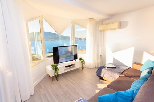 a living room with a tv and large windows at BestVillas Foz do Minho in Caminha