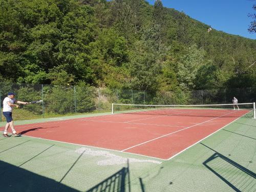 zwei Personen, die Tennis auf einem Tennisplatz spielen in der Unterkunft Vallon des sources digne les bains in Digne-les-Bains