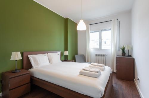 een slaapkamer met een groot bed met groene muren bij FLH Expo Modern Flat with Balcony in Lissabon