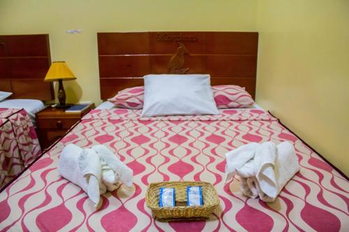 Una habitación de hotel con una cama con toallas. en Alojamiento El Cardenal, en Iquitos