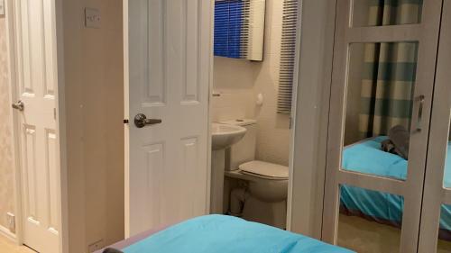 a small bathroom with a toilet and a sink at Woodland Retreat in Swarland