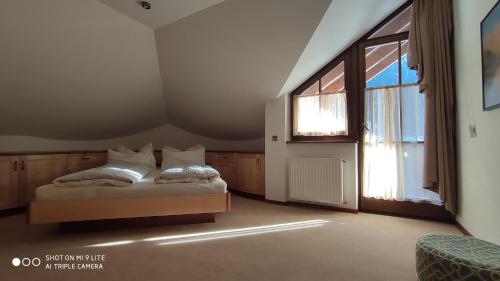 a bedroom with a bed and a large window at Apartment Manuel in Ortisei