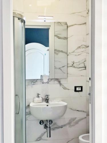 a bathroom with a sink and a mirror at Frida Kahlo appartament in Lacco Ameno