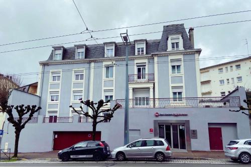 a large white building with cars parked in front of it at Best Western Plus Richelieu in Limoges