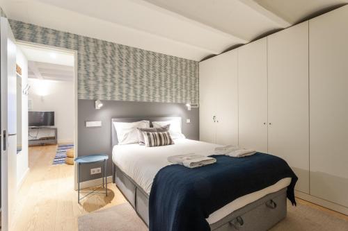 a bedroom with a large bed with a blue blanket at FLH Bairro Alto Elegant Apartment in Lisbon