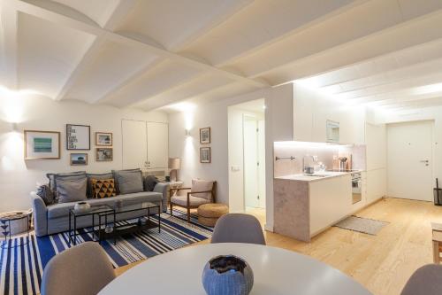 a living room with a couch and a kitchen at FLH Bairro Alto Elegant Apartment in Lisbon