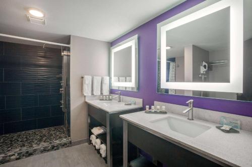 a purple bathroom with a sink and a shower at La Quinta by Wyndham Branson in Branson