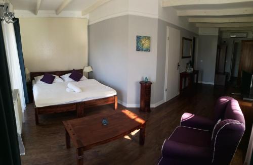 a bedroom with a bed and a couch and a table at Varga Villa in Orfű