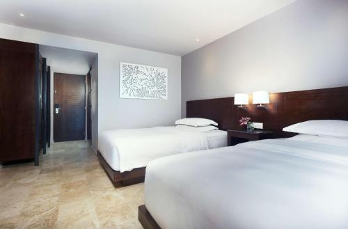 a hotel room with two beds and a hallway at Hyatt Regency Villahermosa in Villahermosa