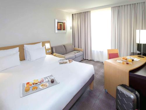 - une chambre d'hôtel avec un lit et un plateau de nourriture dans l'établissement Novotel Perpignan Nord Rivesaltes, à Rivesaltes