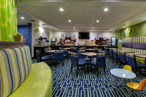 a restaurant with tables and chairs and a bar at Holiday Inn Express & Suites Plant City by IHG in Plant City