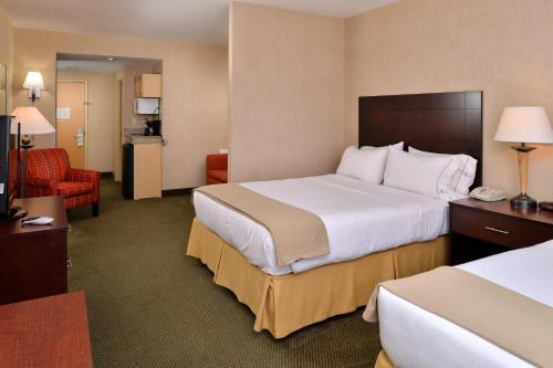 a hotel room with a large bed and a chair at Holiday Inn Express & Suites - Ocean City, an IHG Hotel in Ocean City