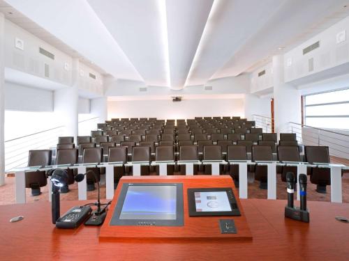 an empty lecture hall with a table and chairs at Mercure Montpellier Centre Comédie in Montpellier