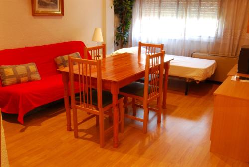 un soggiorno con tavolo, sedie e divano di Apartamentos Goya 75 a Madrid