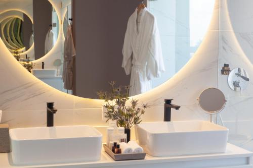 a bathroom with two sinks and a mirror at Cassa Luxury Homes in Bogotá