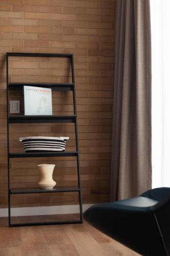 a black shelf with a vase on it in a room at Cassa Luxury Homes in Bogotá