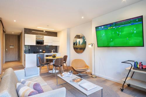 a living room with a couch and a tv on a wall at Cassa Luxury Homes in Bogotá