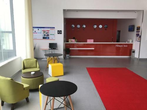 a lobby with chairs and tables and a counter at 7 Days Inn (Hangzhou Xiaoshan Airport West Gate) in Hangzhou