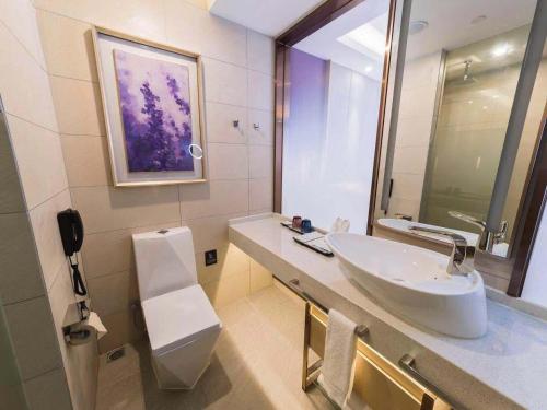 La salle de bains est pourvue d'un lavabo et d'un miroir. dans l'établissement Lavande hotel Jiande Xin'an jiang, à Jiande