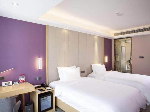 a hotel room with two beds and a television at Lavande hotel Jiande Xin'an jiang in Jiande