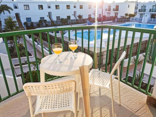 un tavolo con due bicchieri di vino sul balcone di Endless Summer apartment (San valentin) a Corralejo