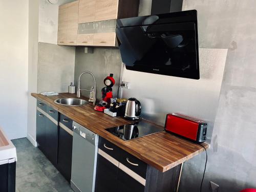 a kitchen with a counter with a sink and a microwave at ADsweet in Épernay