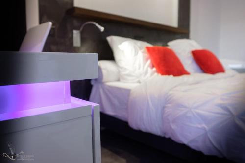 a bedroom with a bed with red and white pillows at ADsweet in Épernay