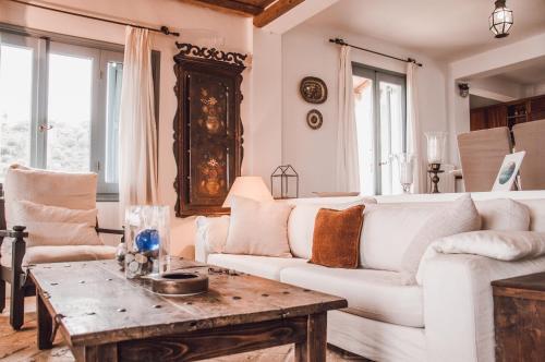 a living room with a white couch and a table at Villa Von Sophia / THE HOUSE in Áyioi Apóstoloi