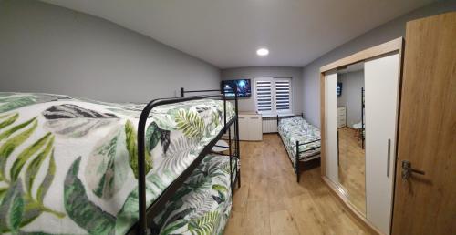 ein Schlafzimmer mit einem Etagenbett, einem Bett und einem Sofa in der Unterkunft Prusa 6 apartamenty in Wieluń