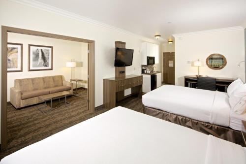 a hotel room with two beds and a couch at Holiday Inn Express Hotel & Suites - Paso Robles by IHG in Paso Robles