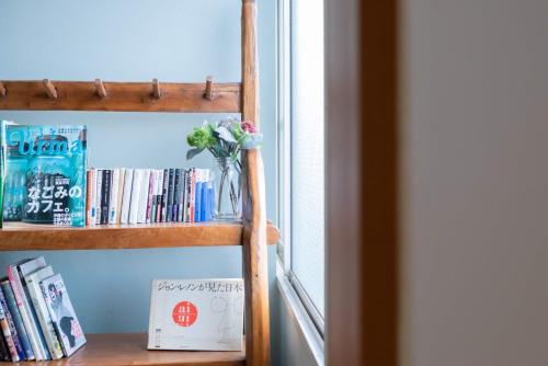 a book shelf with a vase of flowers and books at Kumamoto - Apartment / Vacation STAY 76520 in Kumamoto