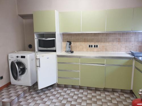 a kitchen with a washing machine and a microwave at Residentie 't Leugentje in Grembergen