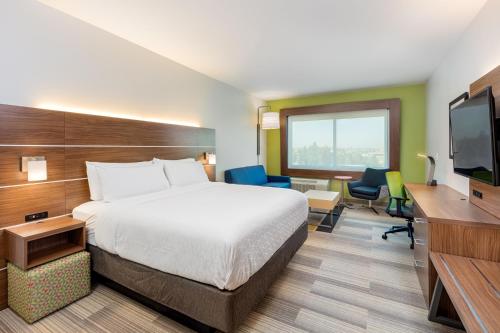a hotel room with a bed and a flat screen tv at Holiday Inn Express & Suites - Moreno Valley - Riverside by IHG in Moreno Valley